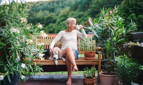 Happy old woman drinks coffee