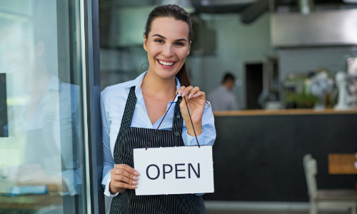 store clerk holding open sign