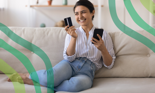 Woman using a credit card and her phone