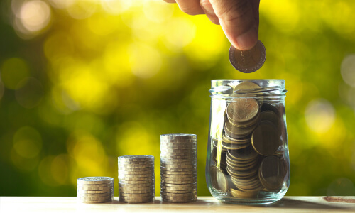 Man putting coins into a jar