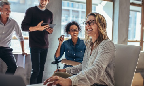 Happy female employee sitting at her desk.