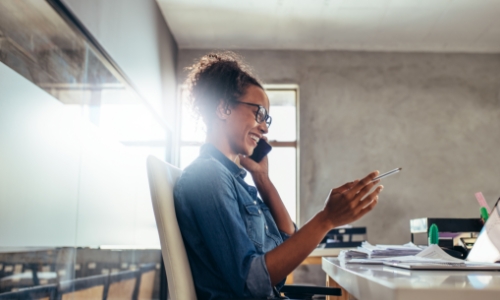 A woman on the phone at her desk