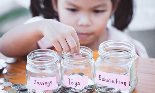 Girl putting coins into a bottle