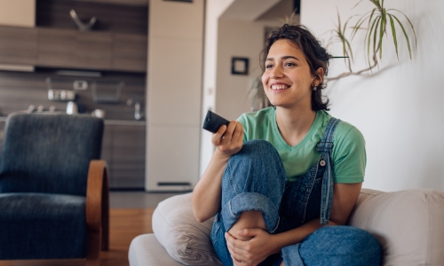 A person sitting on the couch watching television