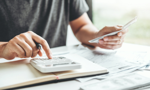 man doing finances with a calculator