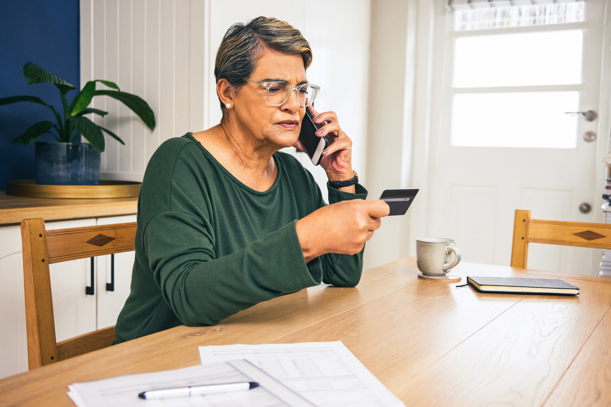 Senior citizen on phone giving scammer her card information