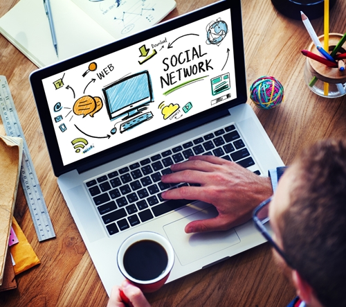 Man drinking coffee while browsing his laptop for social media