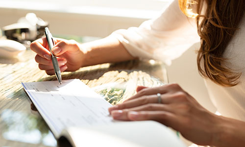 Woman prepares to write a check