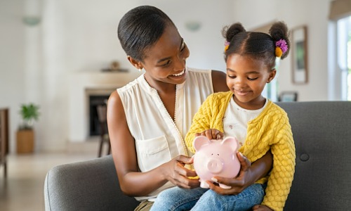 Mother and daughter holding a piggy bank