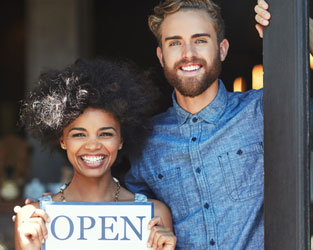 young business owners with open sign