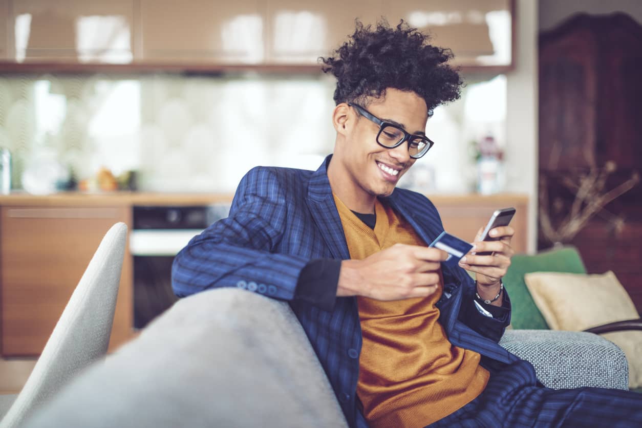 Man using a his credit card and a phone