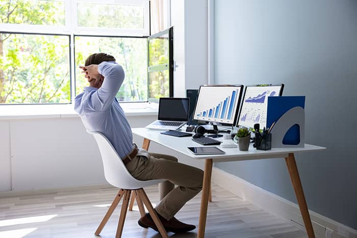 Young man sitting at a desk with 2 computer screens, using the eReceivables platform