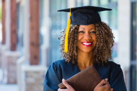 Graduate student holding her diploma to her chest