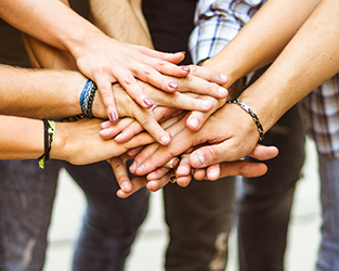 Hands placed on top of each other to make a pact